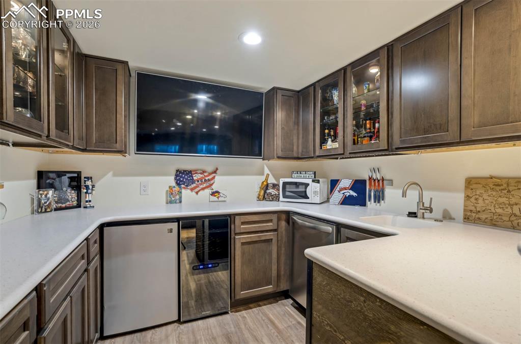  Wet Bar with glass insert cabinets, tv(to stay  as fits the space perfectly), countertop microwave, undercounter fridge and dishwasher, wine fridge(as is) and sink.  