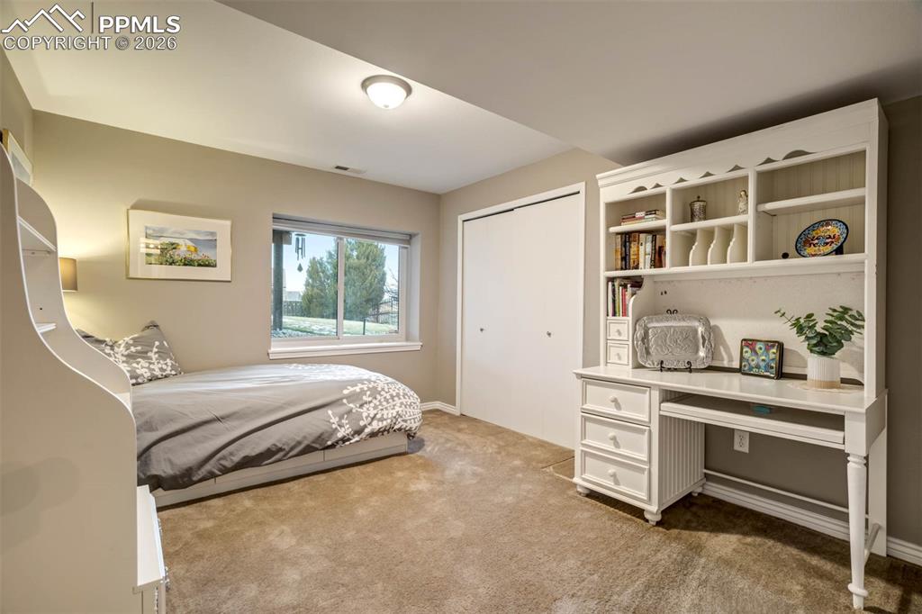Bedroom 5(basement) with large window and light carpet.