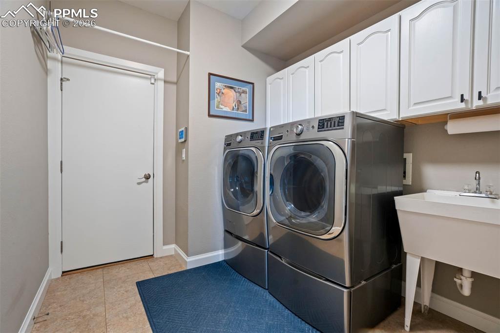 Main floor laundry room (washer and dryer are both excluded), cabinet space, laundry sink and door to the 3-car oversized garage.