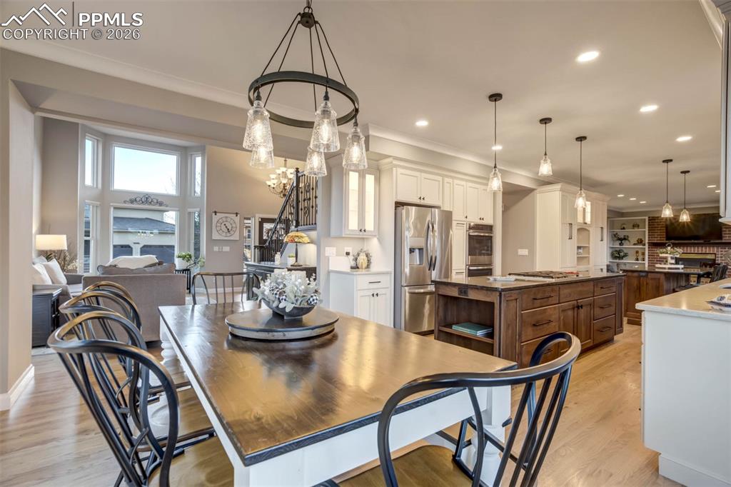 Large Dining area with chandelier, hardwood floors, open to the spacious kitchen with  pendant & recessed lighting, and beautiful custom crown molding. Also open to the light filled living room.