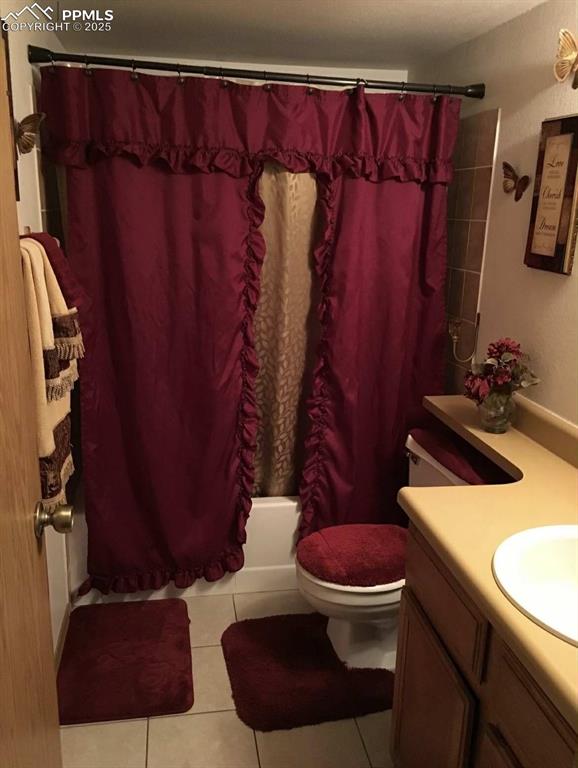 Bathroom featuring vanity, light tile patterned floors, and shower / tub combo with curtain
