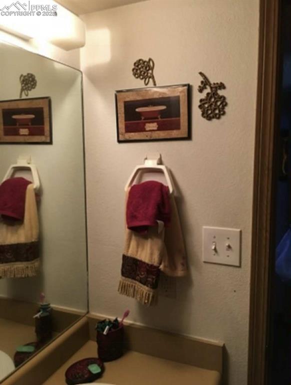 Bathroom featuring vanity and a textured wall