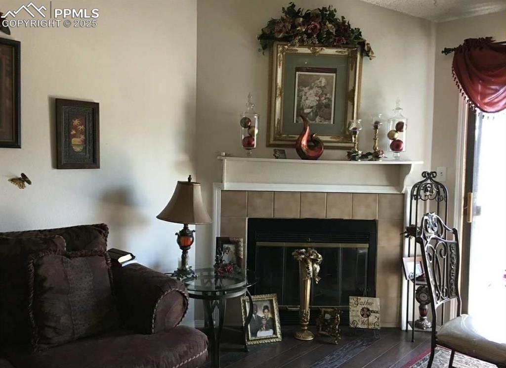 Living area with a tile fireplace and wood-type flooring