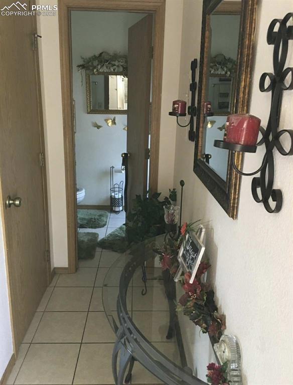 Hall featuring light tile patterned floors and baseboards