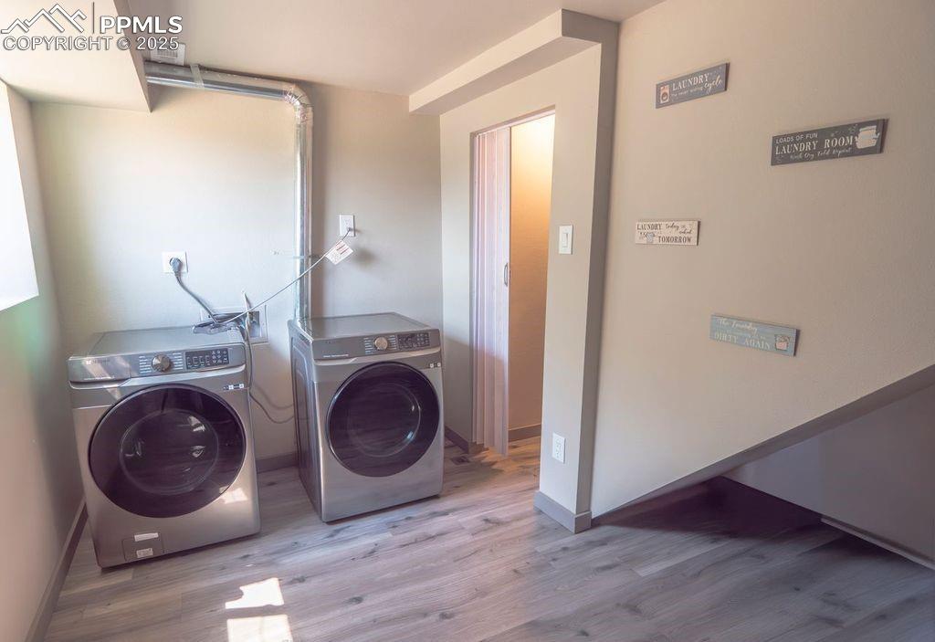 Laundry room featuring washing machine and clothes dryer and wood finished floors