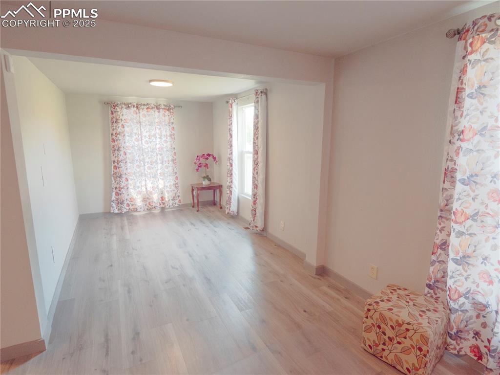 Empty room with light wood-style flooring and baseboards