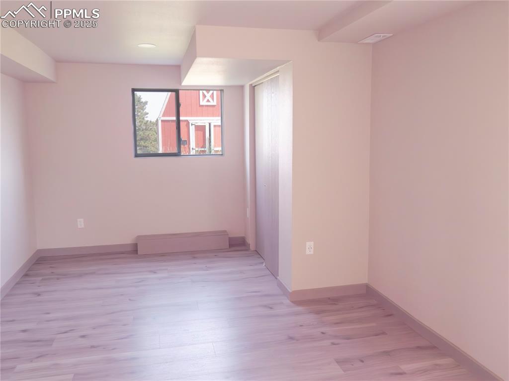 Spare room featuring light wood-type flooring, a baseboard heating unit, and recessed lighting