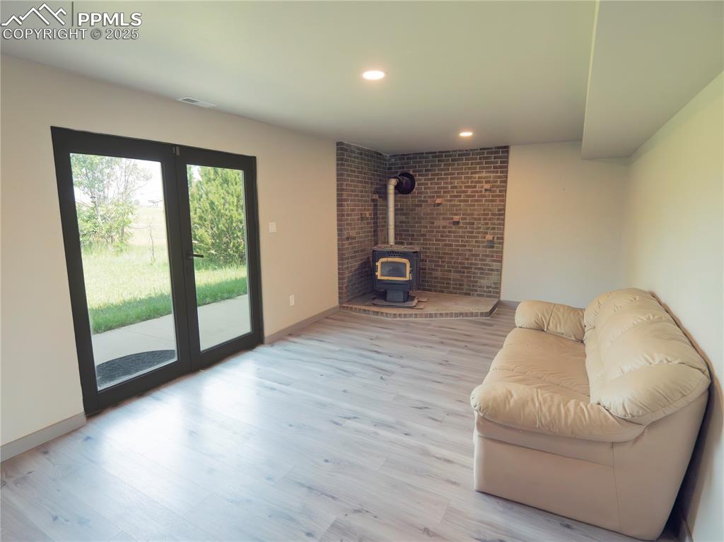 Living area with a wood stove and wood finished floors