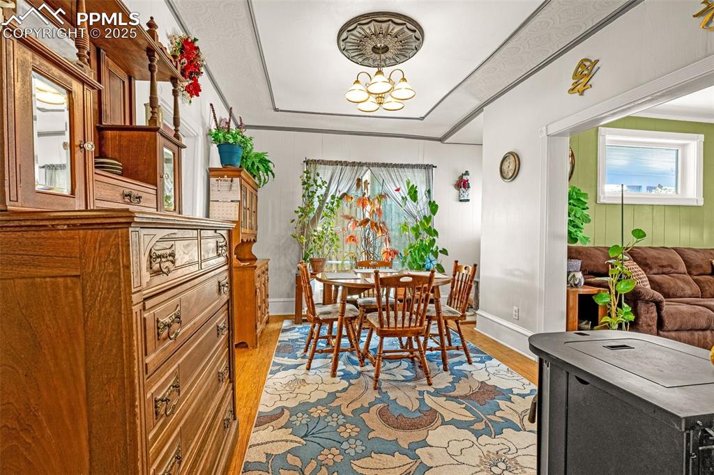 Dining space featuring light wood-style flooring and crown molding