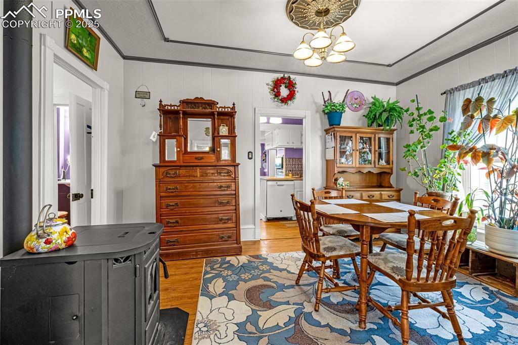 Dining area featuring light wood finished floors, ornamental molding, and a chandelier