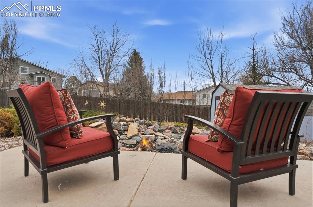 Fenced backyard featuring a patio and firepit