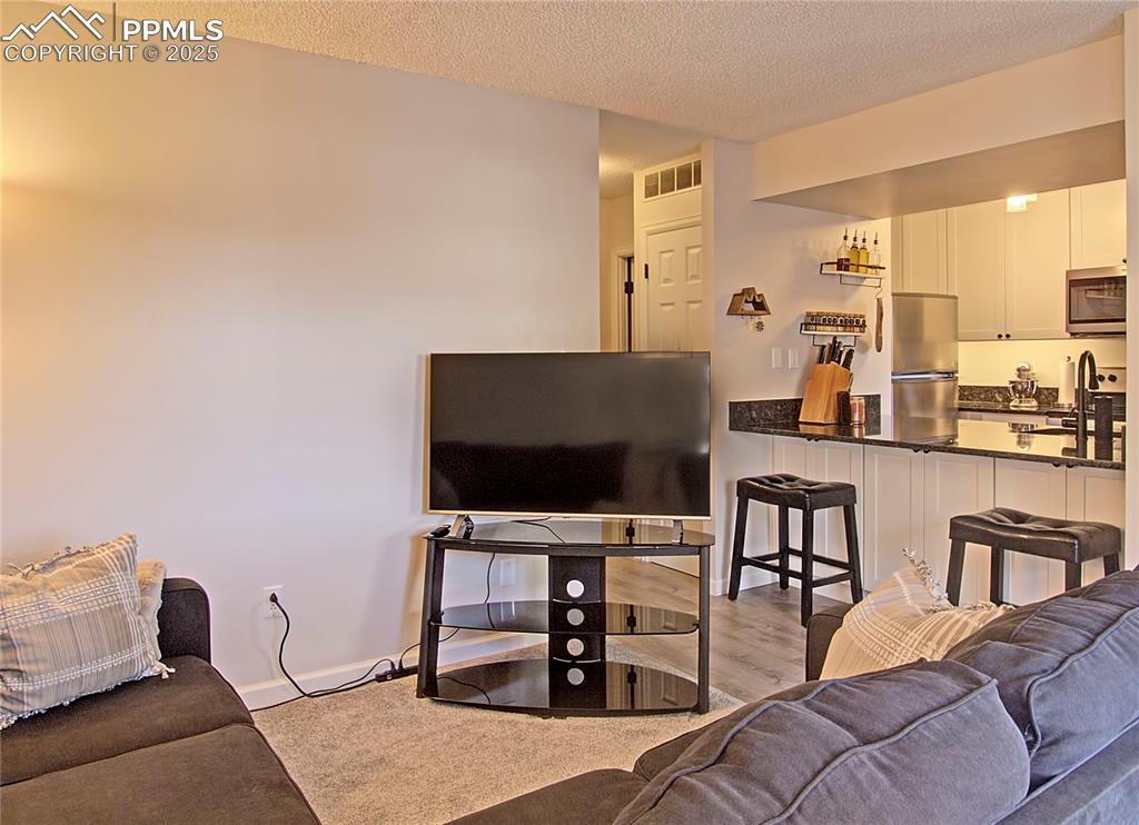 Kitchen has breakfast bar with cabinets for underneath for additional storage.