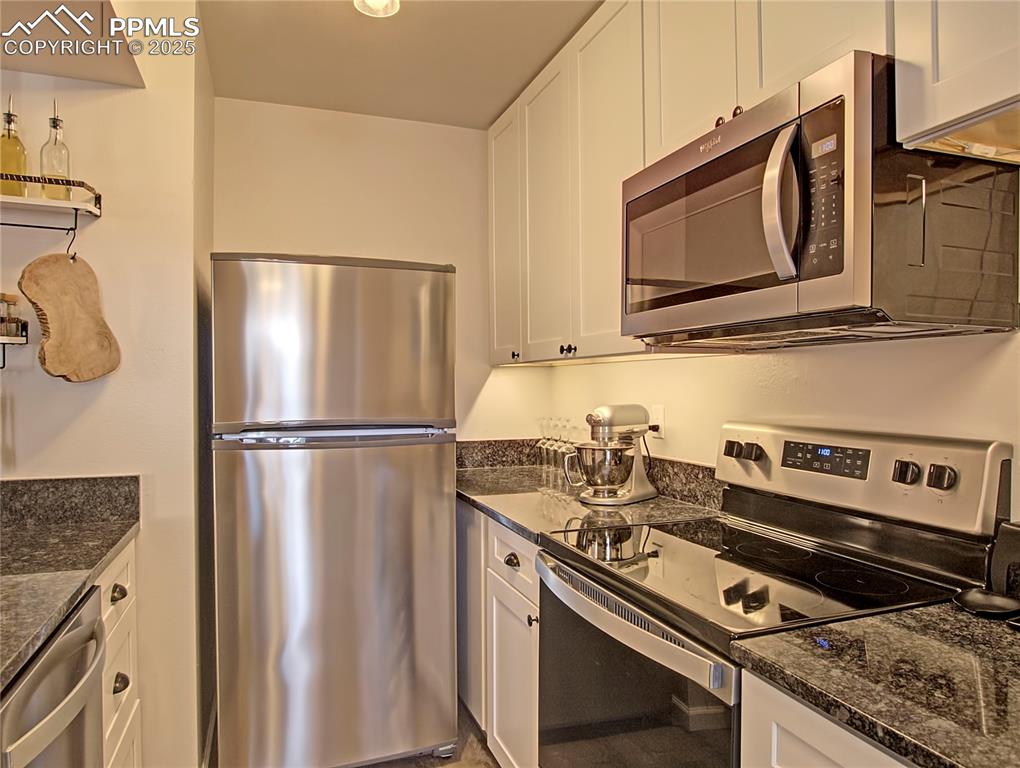 Kitchen has been fully remodeled with stainless steel appliances, spacious white cabinets, & granite countertops.