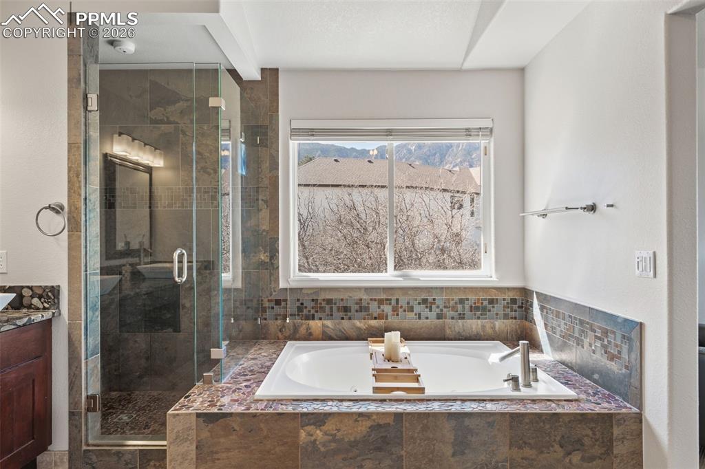 Bathroom featuring a stall shower, a bath, and vanity
