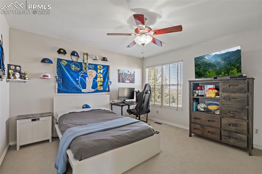 Bedroom with light colored carpet and a ceiling fan