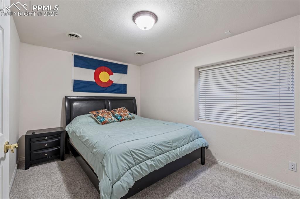 Bedroom featuring light carpet and a textured ceiling