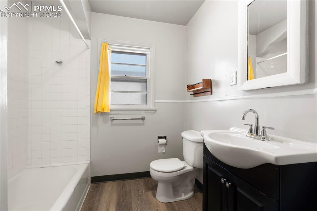 Bathroom featuring vanity, dark wood finished floors, and shower / washtub combination