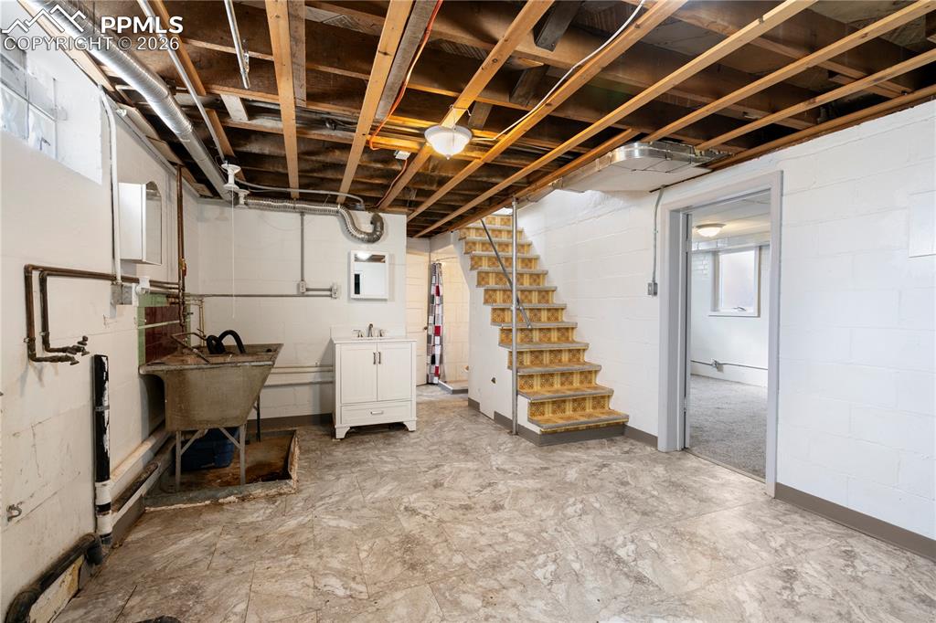 Unfinished below grade area featuring stairway