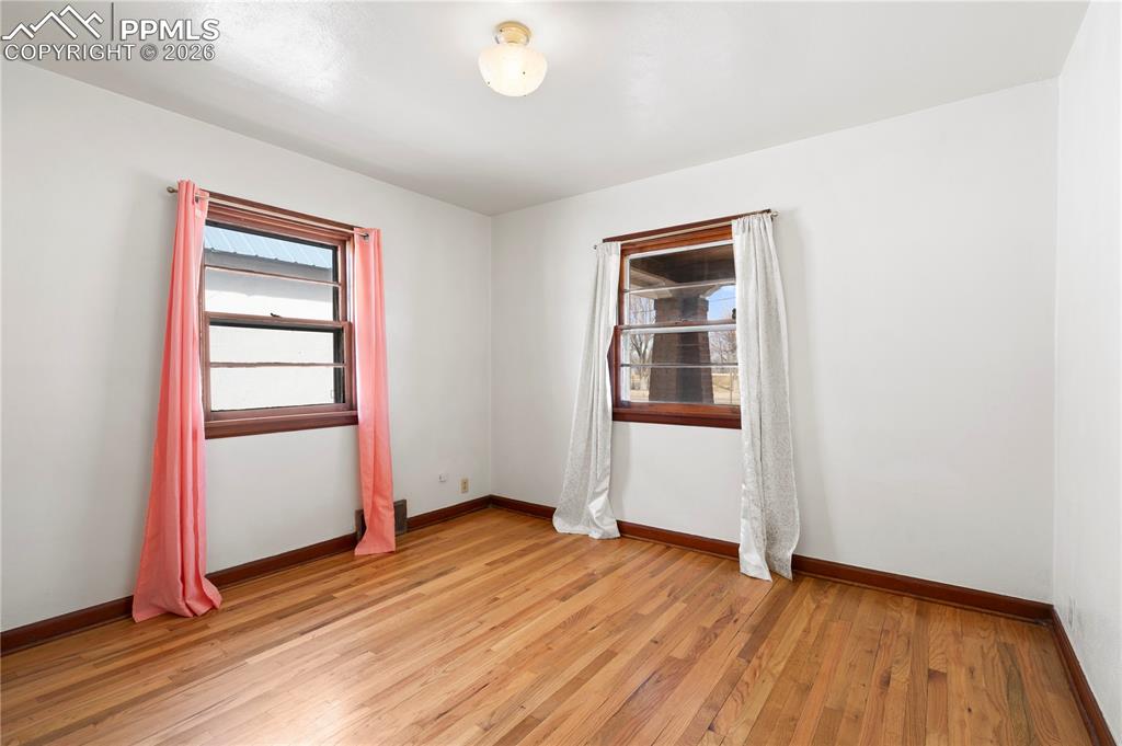 Empty room with light wood-style flooring and baseboards