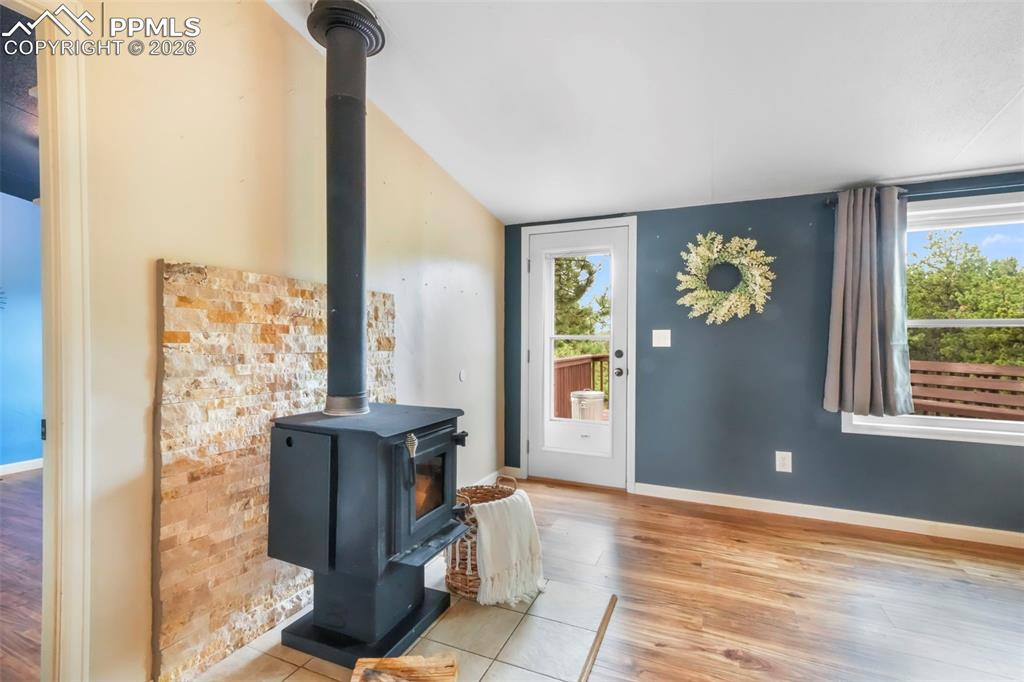 Entrance foyer with a wood stove and light wood finished floors