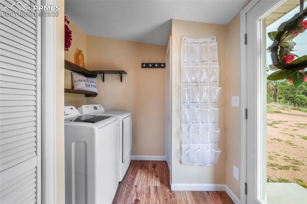 Washroom featuring wood finished floors and washer and clothes dryer