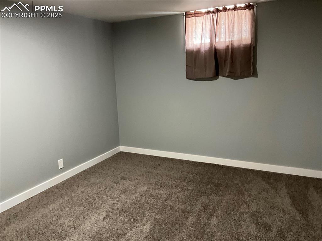 Spare room featuring carpet floors and baseboards