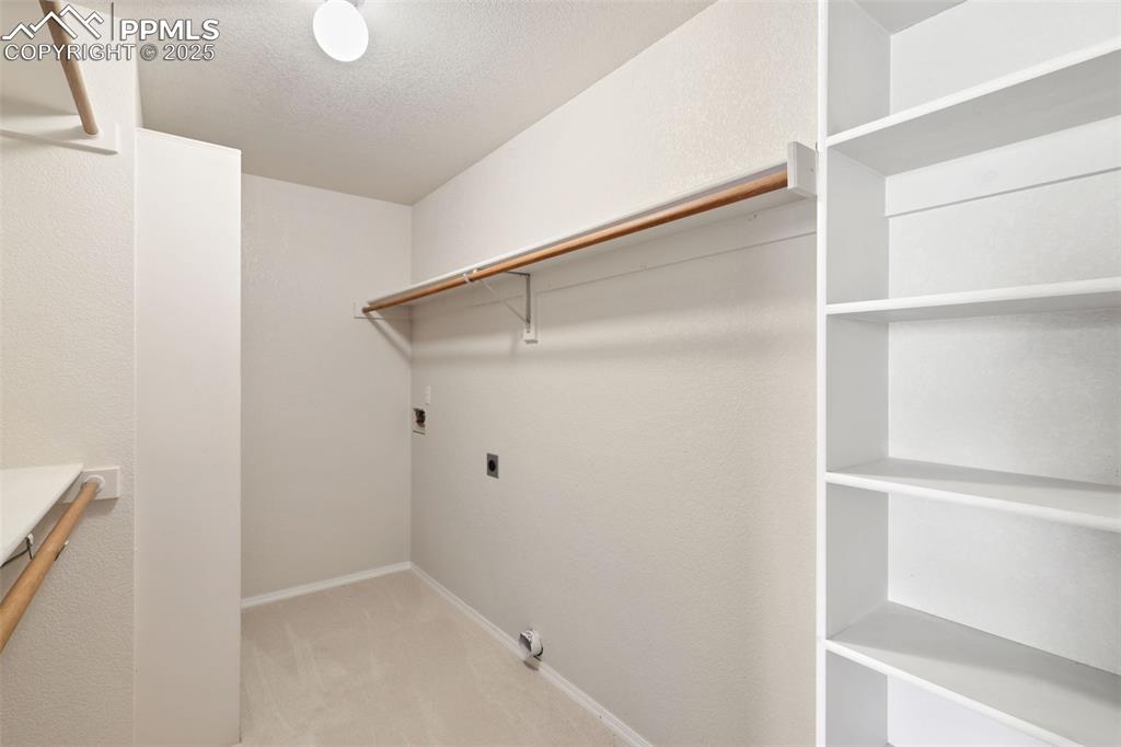 Walk in closet with light carpet