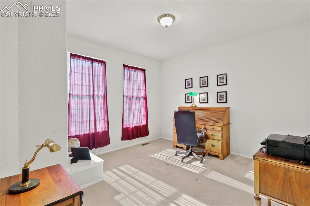 Carpeted office space featuring baseboards