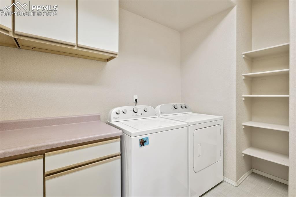 Washroom with cabinet space and washer and clothes dryer