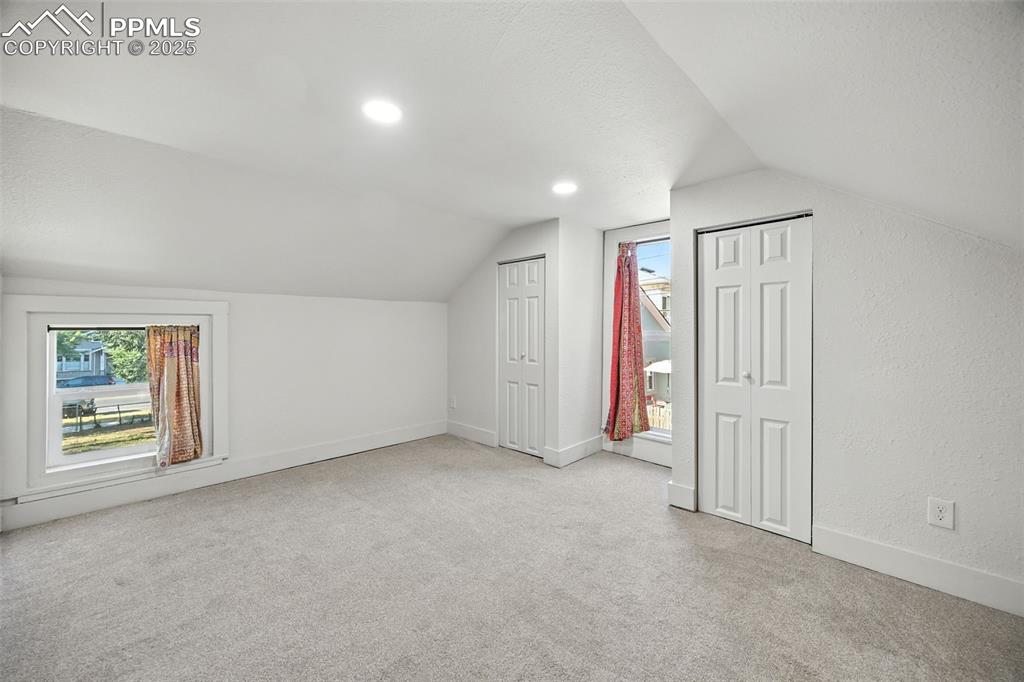 Additional living space featuring light carpet, lofted ceiling, a textured ceiling, and recessed lighting