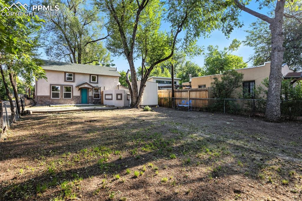Back of house with a fenced backyard, stucco siding, a patio area, and stone siding
