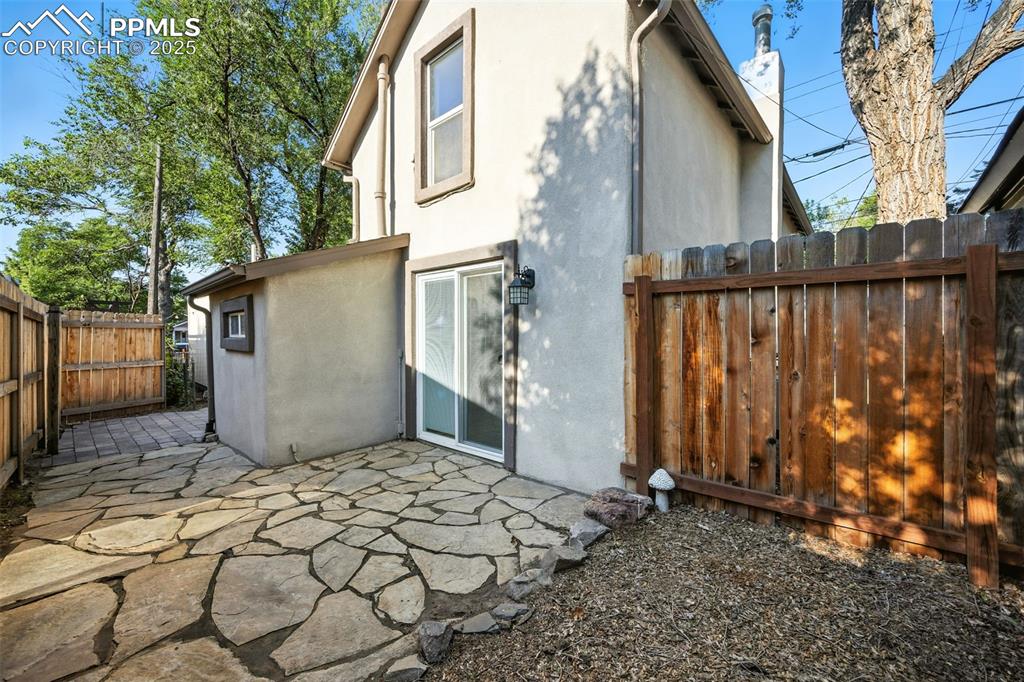 Back of property with stucco siding and a patio