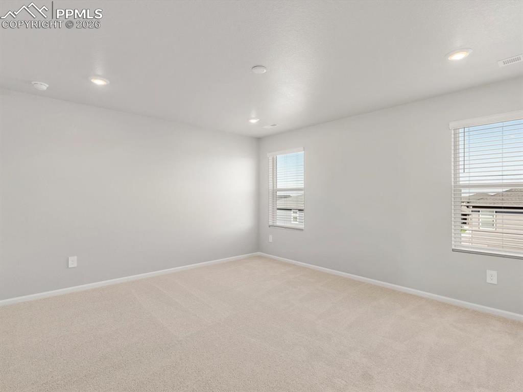 Unfurnished room with light colored carpet and recessed lighting