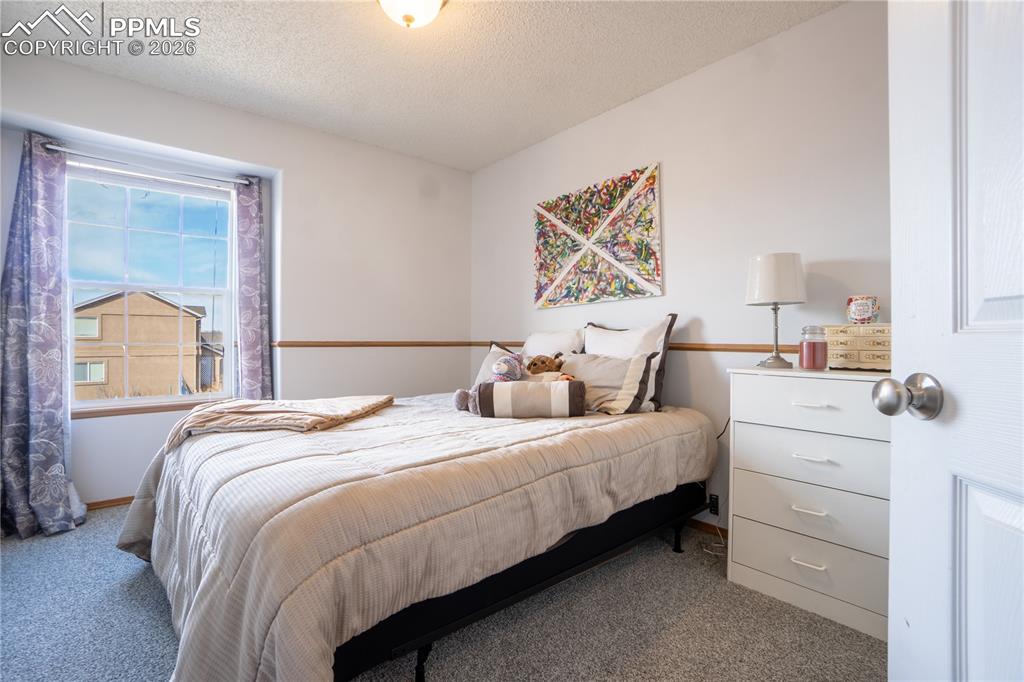 Carpeted bedroom featuring a textured ceiling