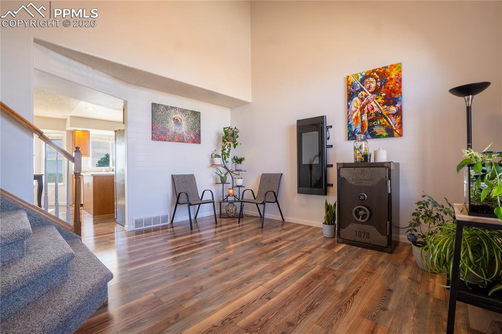 Living area with wood finished floors and a high ceiling