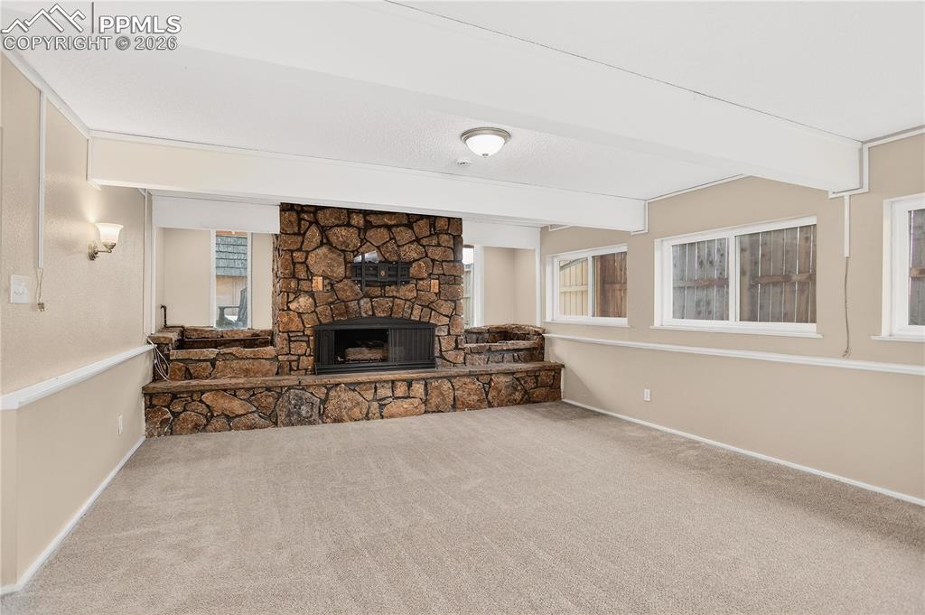 Lower level living space with stone fireplace and abundant natural light.