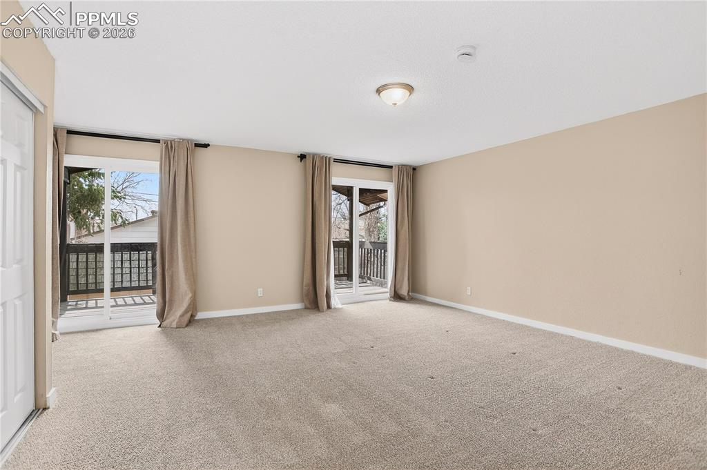 Spacious primary bedroom with large sliding glass doors and deck access.