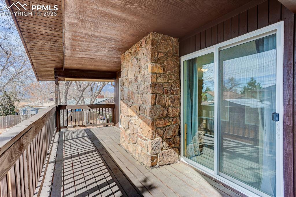 Covered deck off the primary bedroom overlooking the backyard.
