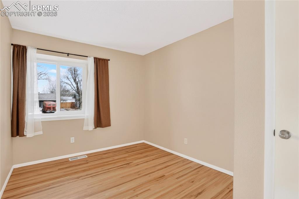 Bedroom with hardwood flooring and natural light.