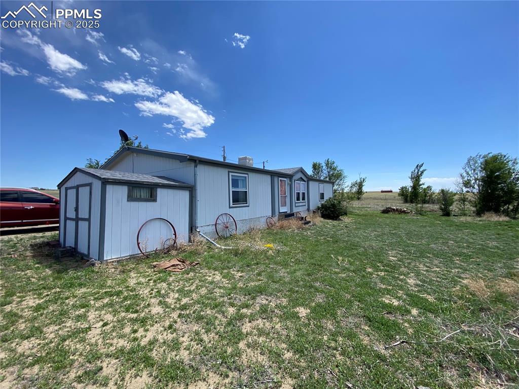 Front of the home featuring a storage shed, providing extra space for tools, outdoor gear, and property maintenance