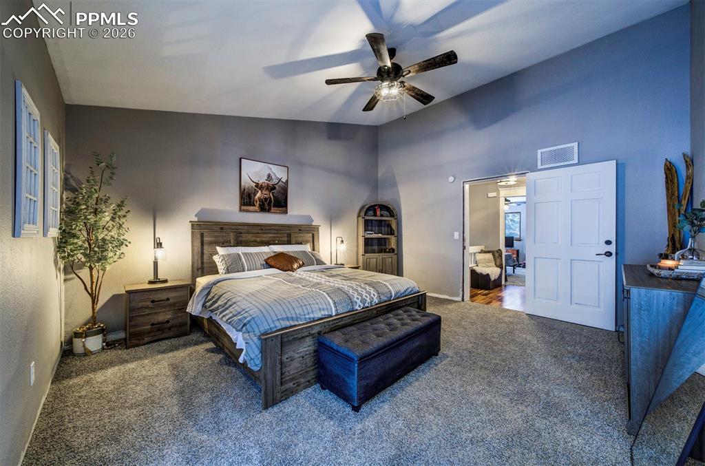 Bedroom featuring carpet, ceiling fan, and lofted ceiling
