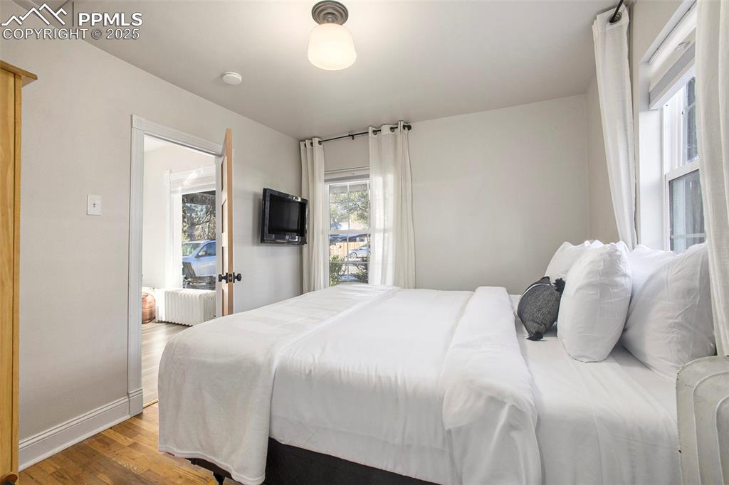 Bedroom with wood finished floors and baseboards