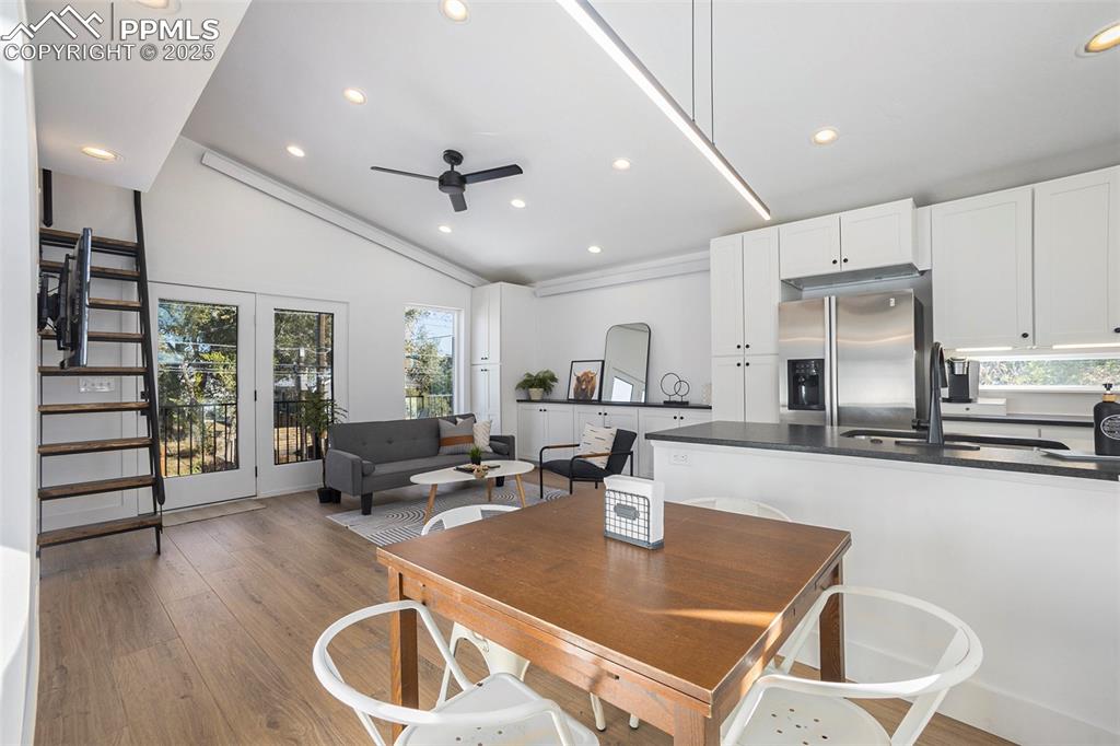Dining room with light wood-style flooring, recessed lighting, ceiling fan, and lofted ceiling