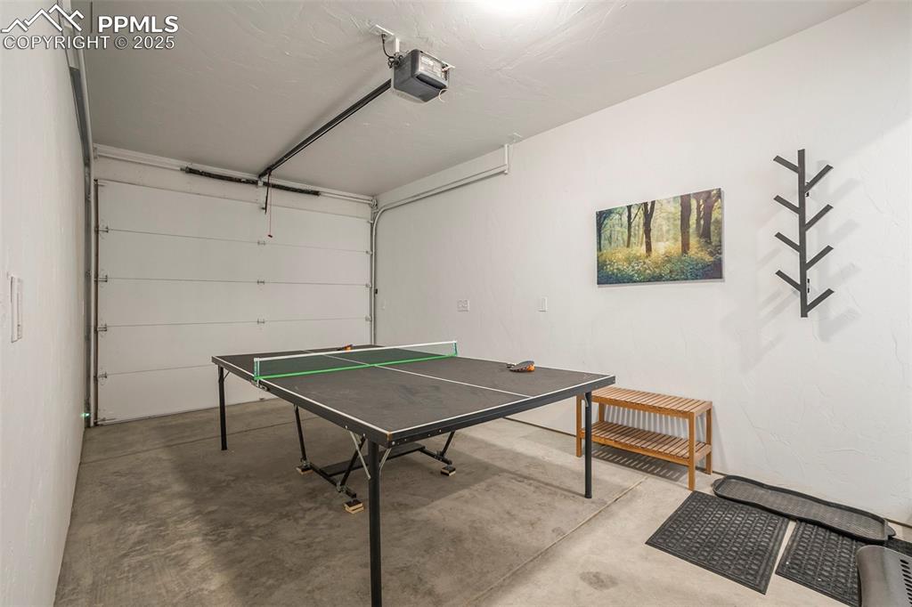 Playroom featuring a garage and unfinished concrete flooring