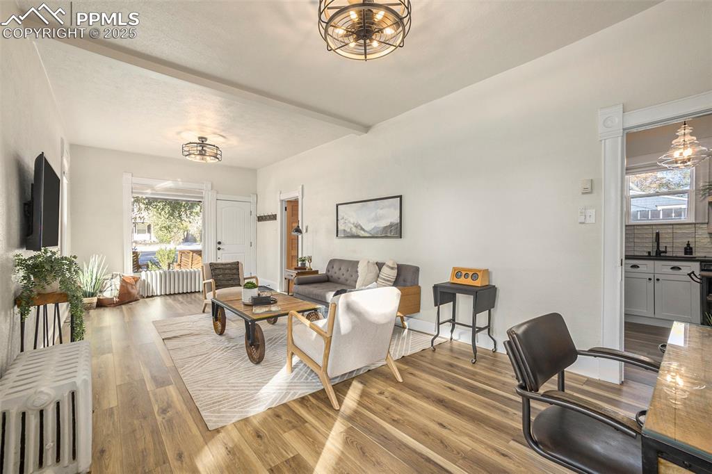 Living area with a chandelier, radiator, and light wood finished floors