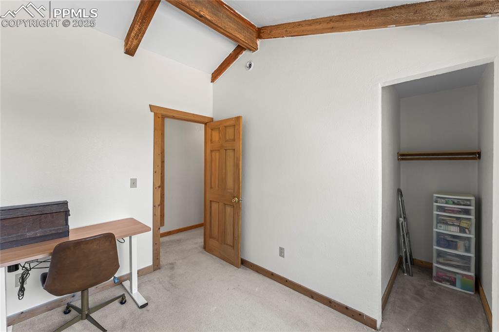 Bedroom with beamed ceiling and closet