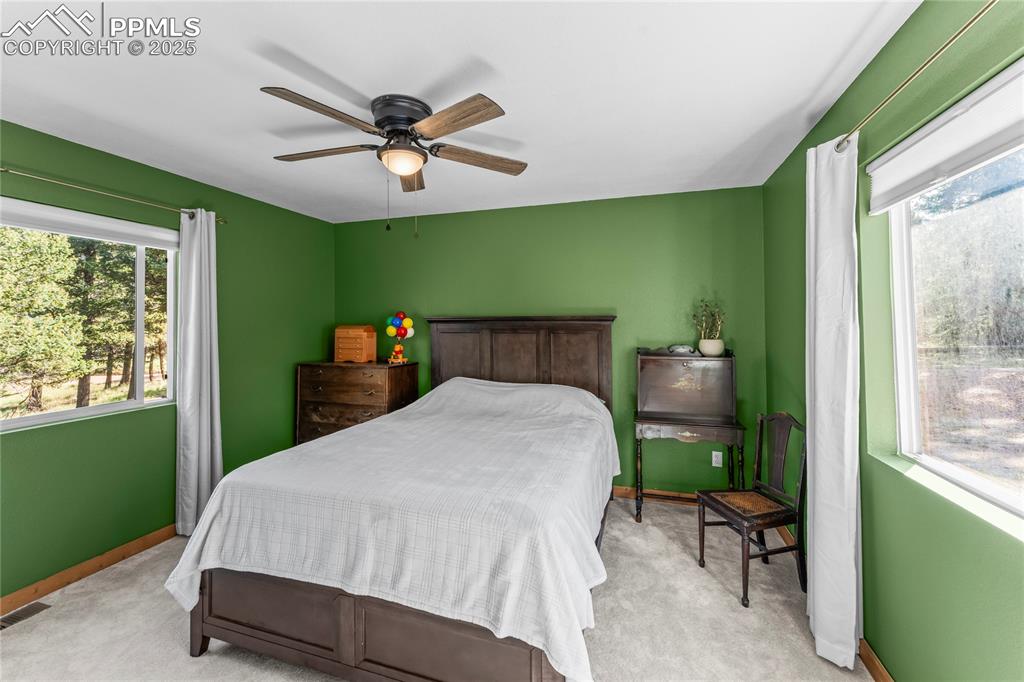 Carpeted bedroom featuring baseboards and ceiling fan