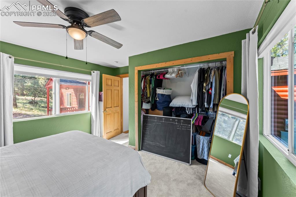Carpeted bedroom with a closet and a ceiling fan