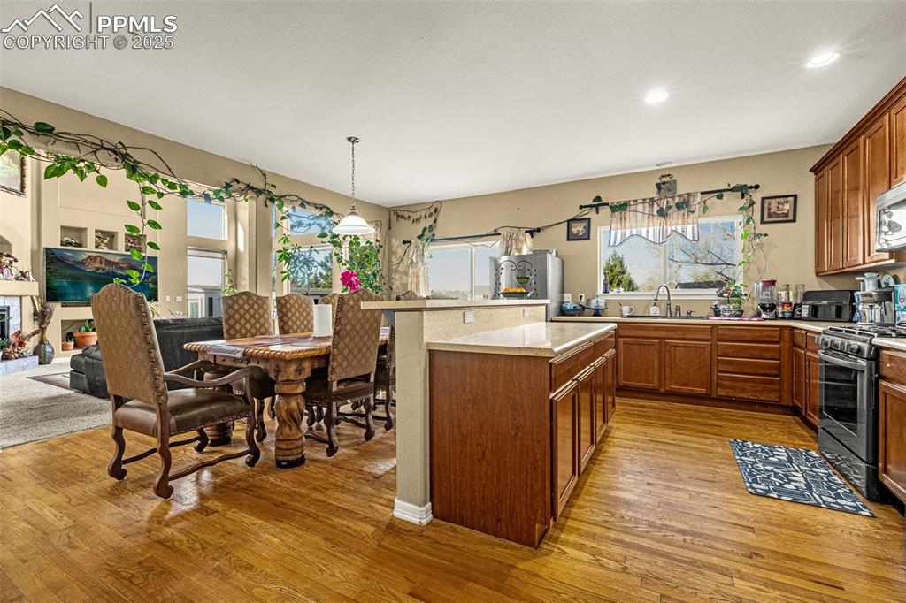 Kitchen featuring light countertops, brown cabinets, stainless steel appliances, plenty of natural light, and recessed lighting