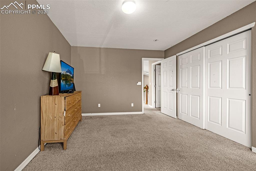 Bedroom with light colored carpet and a closet